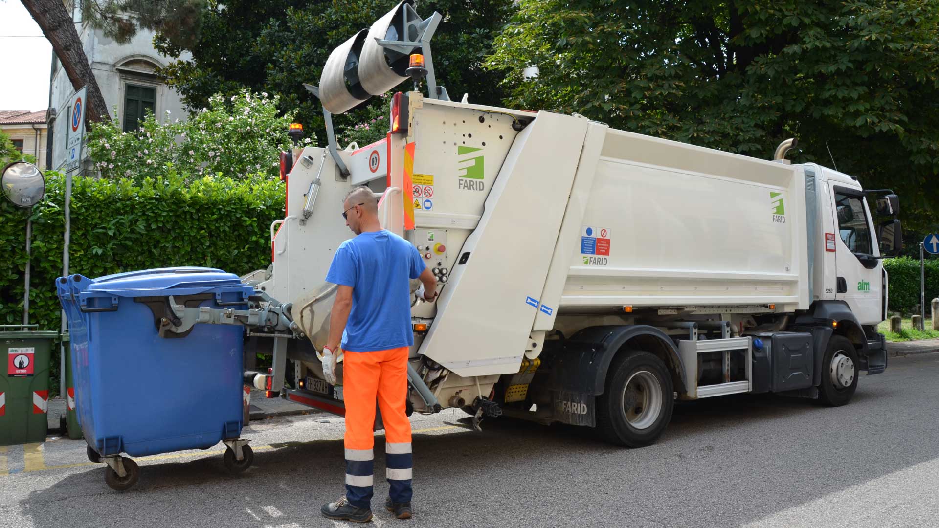 Operaio al lavoro con mezzo mobile di stoccaggio e compressione rifiuti