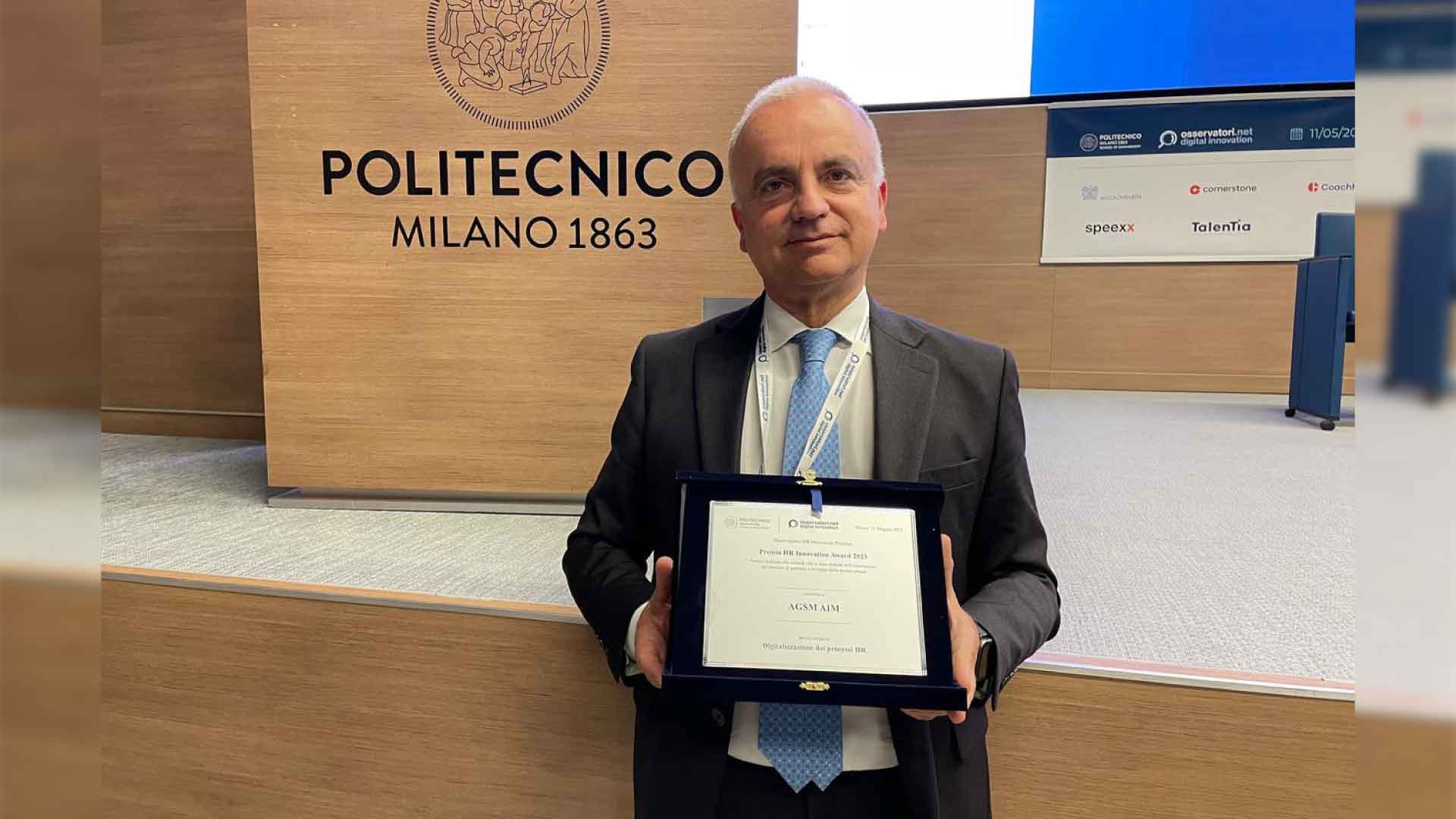 Rappresentante del gruppo con in mano la targhetta premio dell' HR Innovation Award